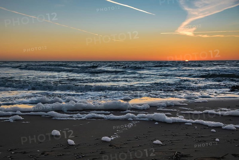 Den Helder, Netherlands. January 2022. Setting sun on the beach of Den Helder, Netherlands.