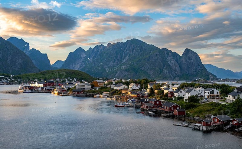 Village view of the fishing village Reine, Traditional red Rorbuer cabins, at sunset, rocky mountains in the back, Lofoten, Nordland, Norway, Europe