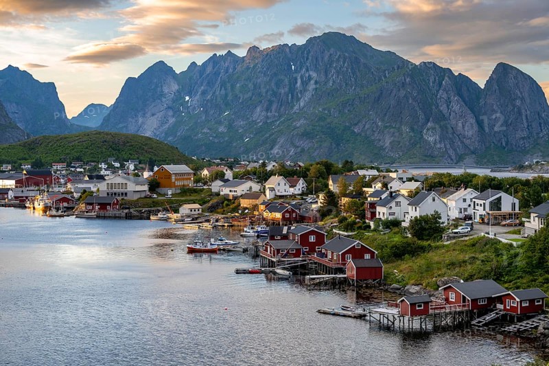Village view of the fishing village Reine, Traditional red Rorbuer cabins, at sunset, rocky mountains in the back, Lofoten, Nordland, Norway, Europe