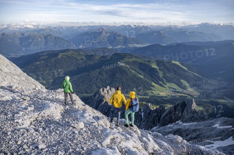 Three hikers look down into the valley from the Hochkönig, Salzburger Land, Austria, Europe