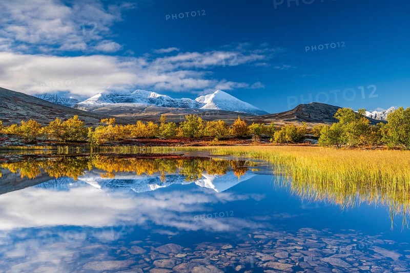 Reflection of the autumn landscape in Rondane National Park, snow-capped mountains, Doraldalen, Norway, Europe