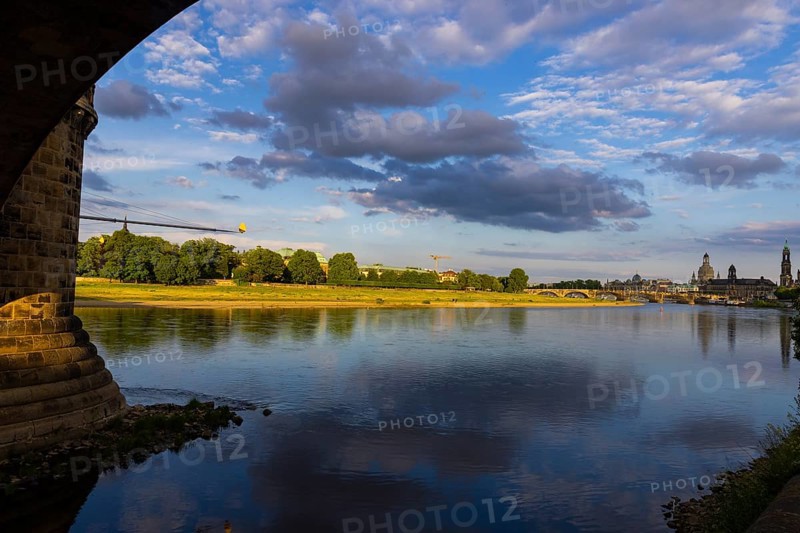 View through the arches of the Marienbrücke onto the Elbe meadows in Dresden's Old Town with silhouette
