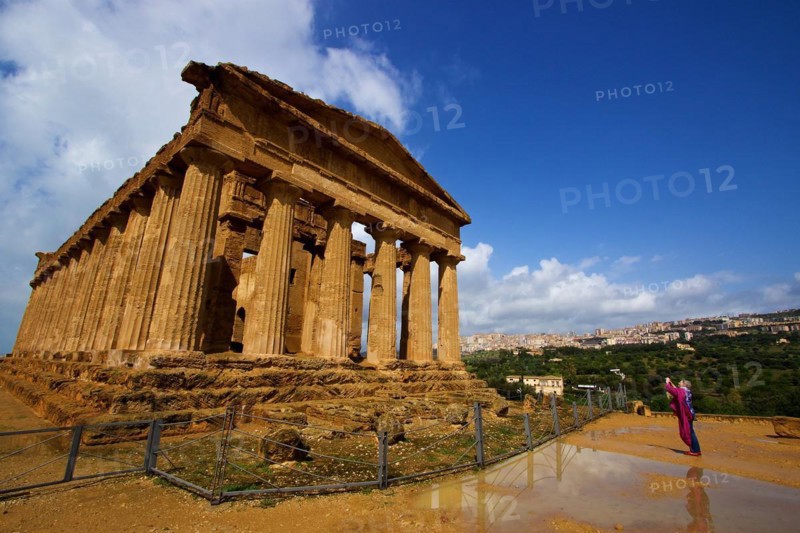 Super wide angle shot, puddle of rain, post-thunderstorm mood, visitor photographing the temple, Agrigento, city view, Concordia Temple, valley of the temples, valle dei templi, Agrigento, Sicily, Italy, Europe