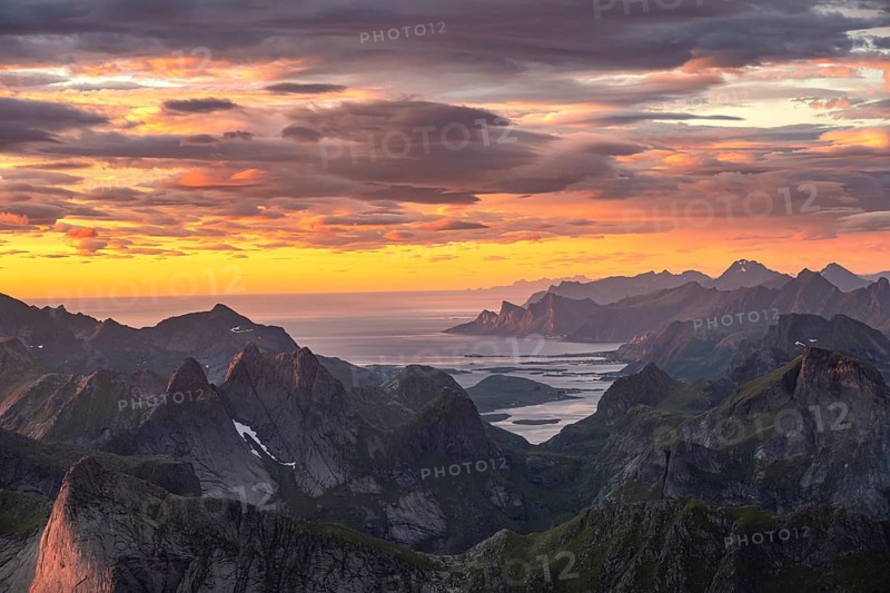 View over mountain top and sea to Fredvang, dramatic sunset, from the top of Hermannsdalstinden, Moskenesöy, Lofoten, Nordland, Norway, Europe