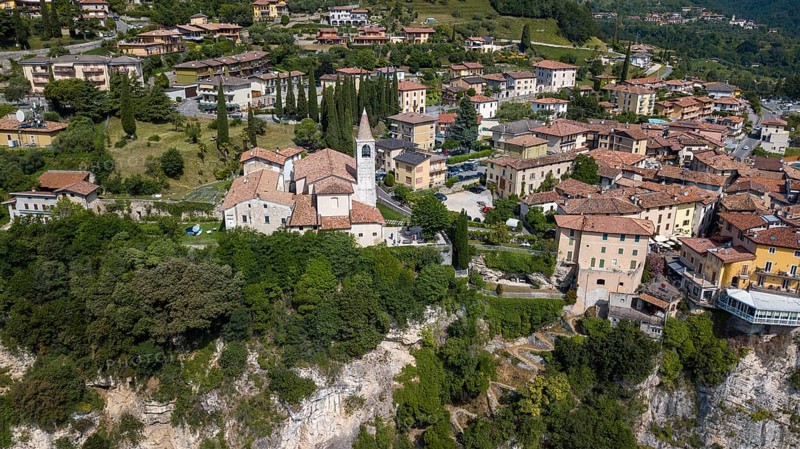 View of village resort Tremosine in the middle Catholic church Chiesa di Pieve on steep rock face at Lake Garda Lago di Garda, Tremosine, province Brescia, region Lombardy, Italy, Europe