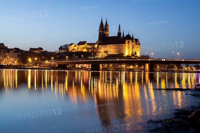 The Elbe in Meissen is slightly high water after the snow has melted, the Burgberg is reflected in the river at blue hour