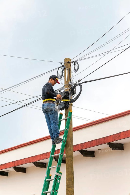 Electrician on ladder working on electricity power lines, Bacalar, Quintana Roo, Yucatan Peninsula, Mexico, Central America