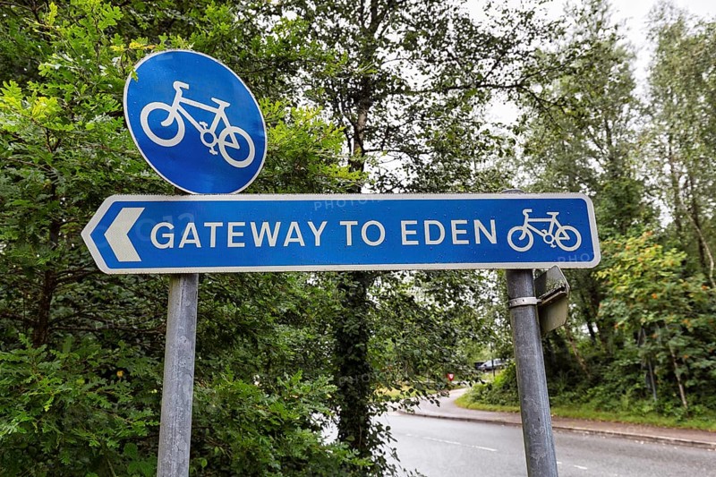 Blue traffic sign in the rain, cycle path, original signpost with inscription, Gateway to Paradise, Eden Project, Cornwall, Great Britain