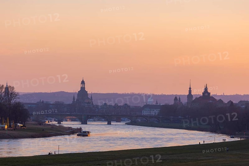 Evening sky over the old town of Dresden with the Church of Our Lady, the castle tower, the Hofkirche and the State Chancellery. In the foreground the Ferry Garden and the Elbe ferry