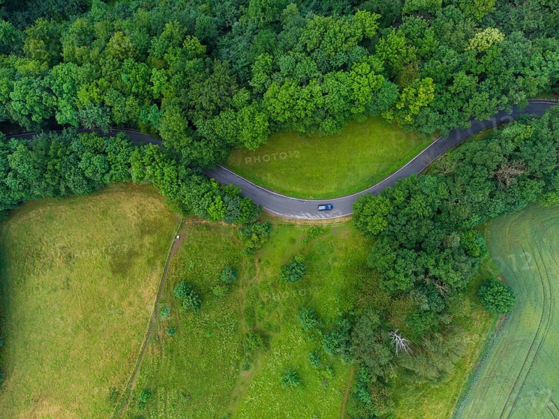 Winding country road with car near Wildenfels in the Ore Mountains