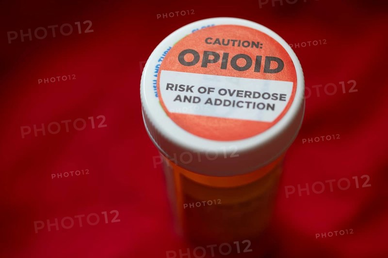 A label on a bottle of hydrocodone-acetamin opioid prescription pills warns against the danger of overdose and addiction