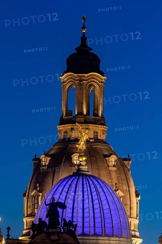 The portal of the new Saxon art society, the Fama dome and the dome of the Church of Our Lady in the evening. In protest against the Ukraine war, the glass dome glows blue
