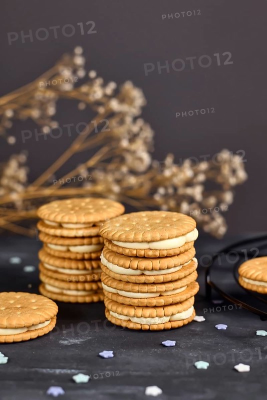 Stack of cream filled sandwich double cookies on dark background