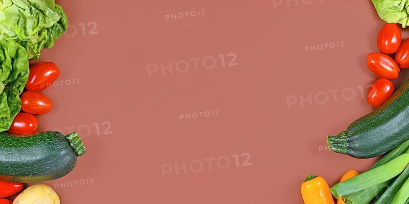 Banner with healthy vegetables with salad, zucchini, tomatoes, potatoes and bell pepper framing blank brown background with copy space
