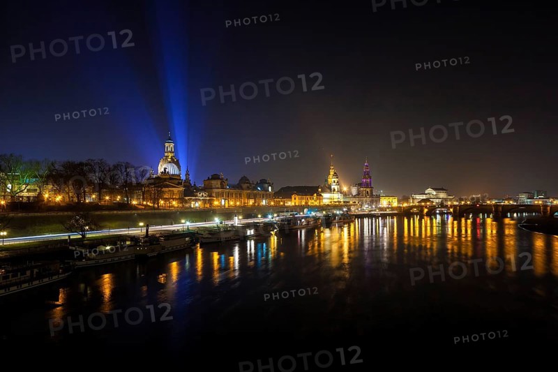 Dresden Silhouette View of the Old Town from the Carola Bridge. On the occasion of the commemoration of the 70th anniversary of the destruction of Dresden, floodlights shine into the night sky at the Church of Our Lady