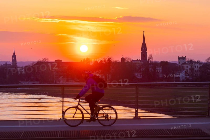 Evening sky over the Elbe with cyclist and tower of the Martin Luther Church seen from the Waldschlösschen Bridge