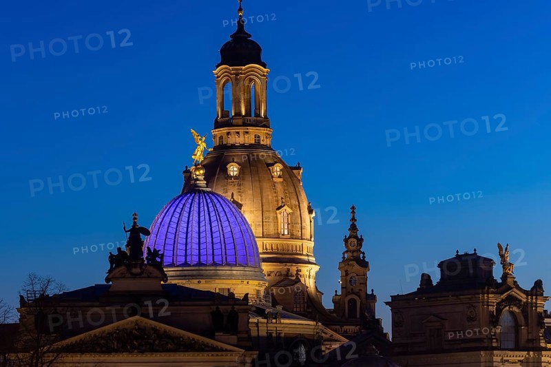 The portal of the new Saxon art society, the Fama dome and the dome of the Church of Our Lady in the evening. In protest against the Ukraine war, the glass dome glows blue
