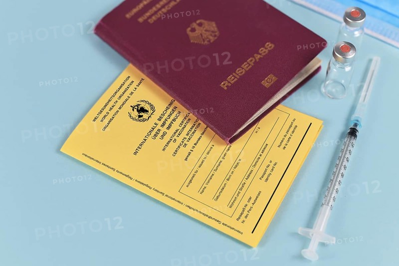 Concept for travel restrictions for people without corona virus vaccination with international certificate of vaccination, German travel passport, syringe and vials