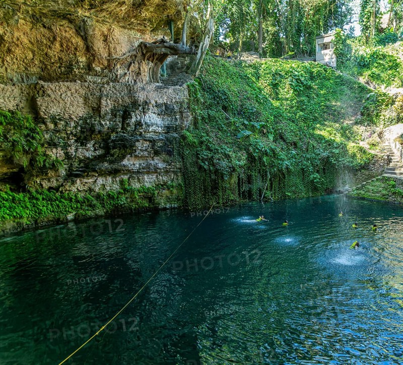People swimming in Cenote Zaci carboniferous limestone swallow hole pool, Valladolid, Yucatan, Mexico, Central America