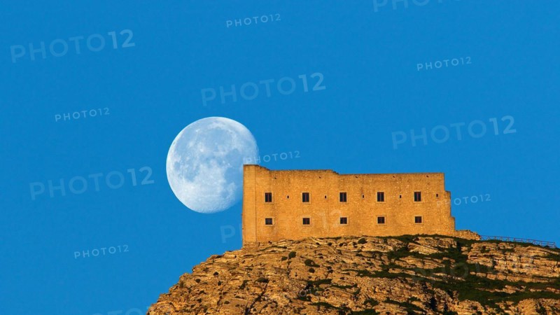 Morning light, super clear blue sky, huge full moon, fortress-like building on the mountain, supertele shot, Erice, Trapani province, mountain, Sicily, Italy, Europe