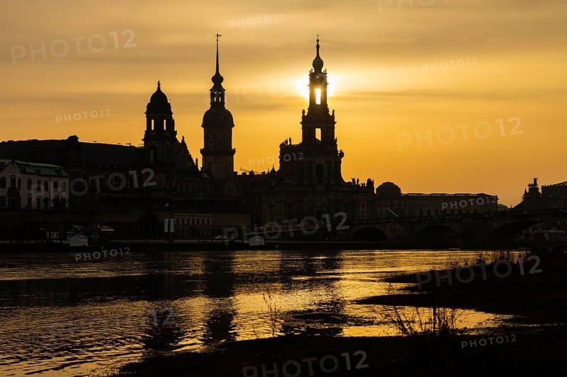 Sunset in Dresden. The sun disc, particularly orange due to the Sahara dust, sets behind the silhouette of Dresden's old town