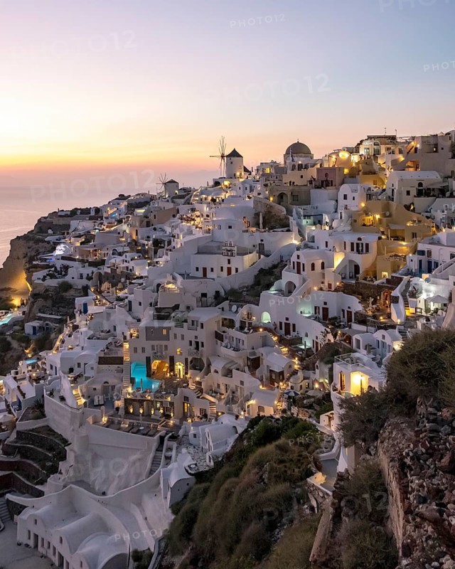 Cliff-side houses, villas and windmill in the village of Oia, Ia, at nightfall, Santorini, Greece, Europe