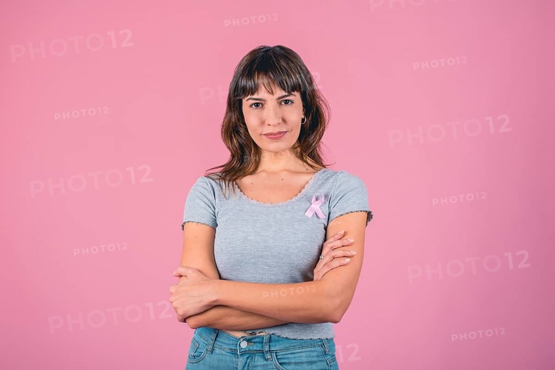 Serious woman wearing pink breast cancer awareness ribbon