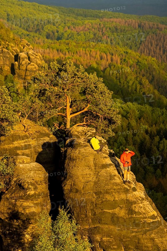 Schrammstein view in the Elbe Sandstone Mountains Looking up the Elbe. Leisurely hikers clamber around unsecured on the rocks, which often leads to falls with dramatic consequences