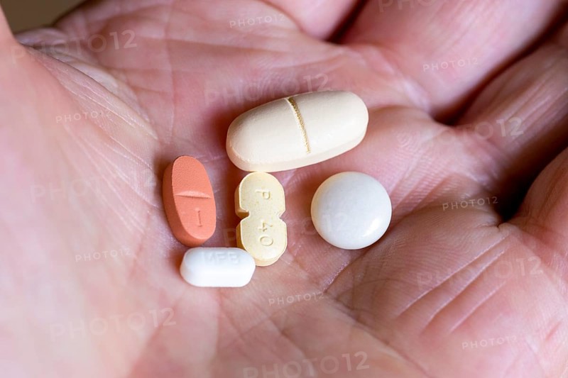 Hand holds various tablets, medicines