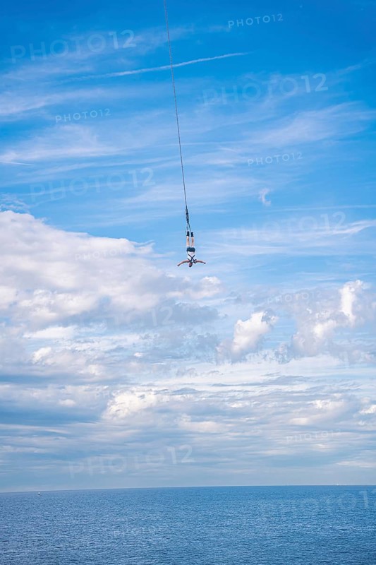Bungy jumper on the rope over the sea, The Hague, Netherlands