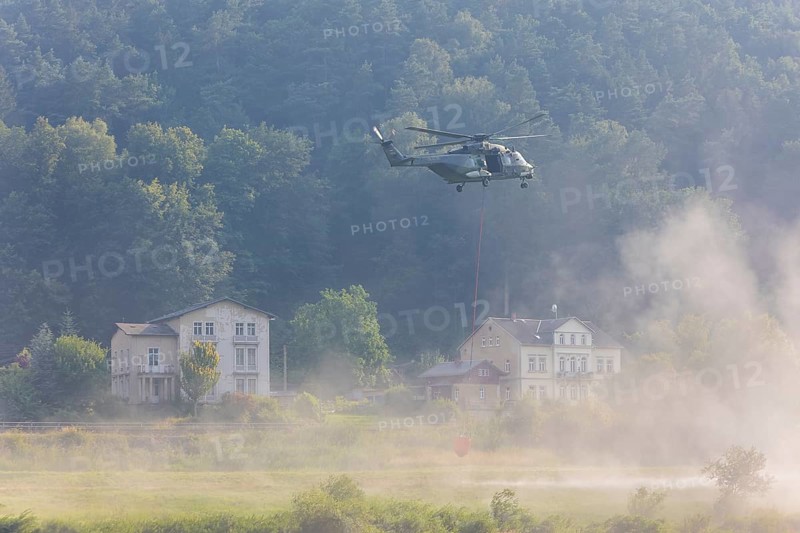A Bundeswehr helicopter lands on the Elbe meadows in Bad Schandau on the Elbe, after a day of fire-fighting operations