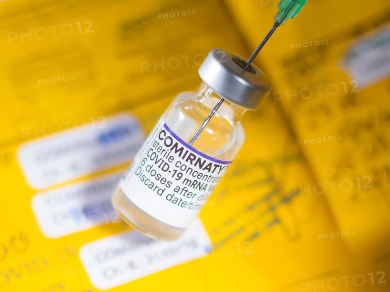 Symbolic image Corona vaccine Comirnaty in front of a vaccination certificate