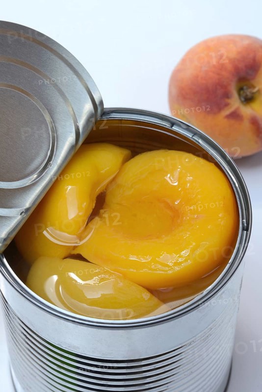 Peach, preserved peach halves with syrup in a tin can