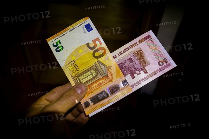 Due to the Ukraine crisis, currencies are also the subject of conflict. A 50 rouble note and a 50 euro note in one hand