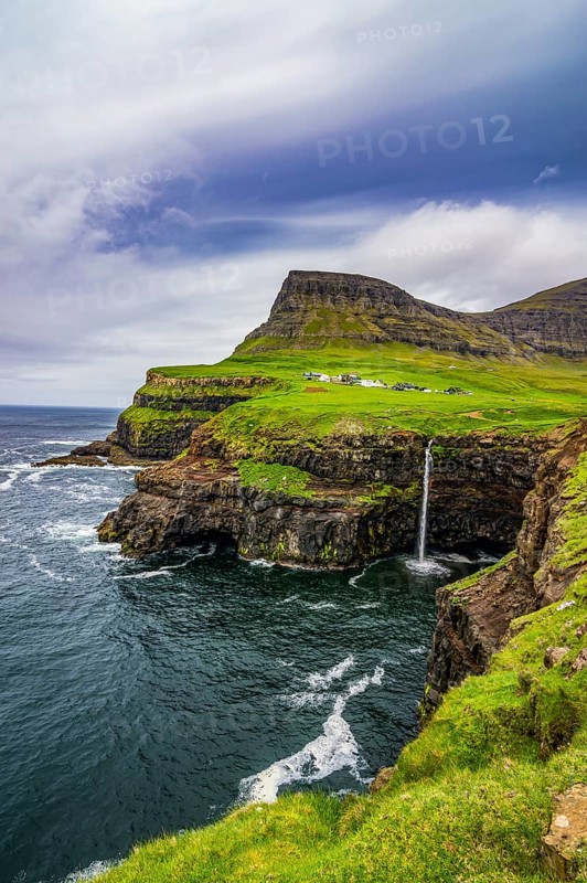Gasadalur waterfall into the ocean, Vagar, Faroe islands, Denmark, Europe