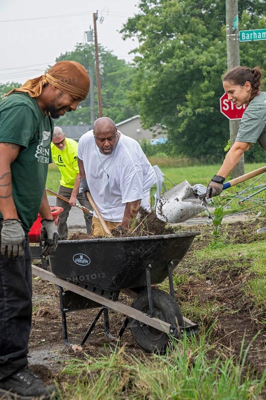 Detroit, Michigan, Volunteers clear weeds and grass in preparation for planting a roadside garden in the Morningside neighborhood