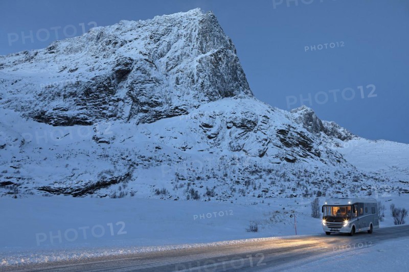 With motorhome in winter on Flakstadveien (E10) in front of the mountain Stortinden