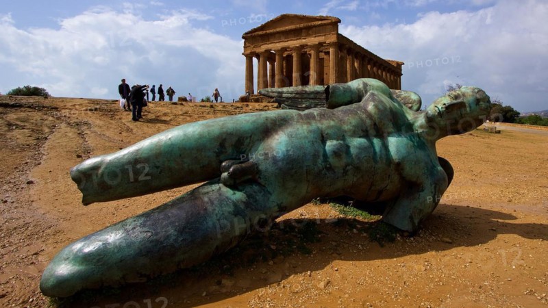 Super wide angle shot, bronze statue of fallen Icarus, Concordia Temple, Valley of the Temples, valle dei templi, Agrigento, Sicily, Italy, Europe
