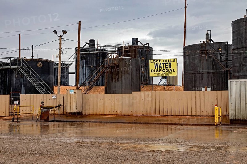 Loco Hills, New Mexico, Tanks hold produced water for disposal amid the oil wells of the Permian Basin. Produced water is a byproduct of oil or gas production. The company disposes of it in evaporation ponds