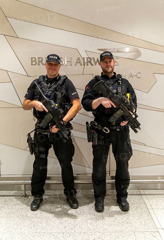 Two armed police officers on duty inside South Terminal, London Gatwick airport, England, UK