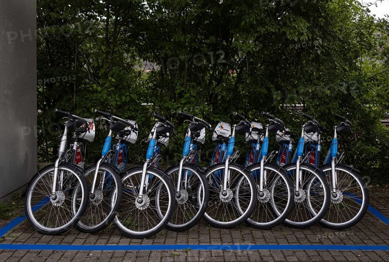 Bicycles for hire, rental bikes, e-bikes of the bicycle and pedelec rental system RegioRadStuttgart polygo, S-Bahn and DB stands leaning against a fence, Stuttgart, Baden-Württemberg