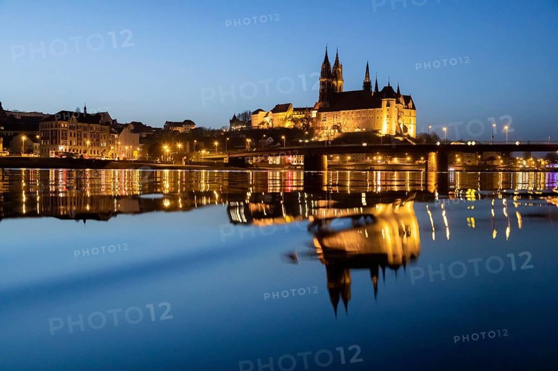 The Elbe in Meissen is slightly high water after the snow has melted, the Burgberg is reflected in the river at blue hour