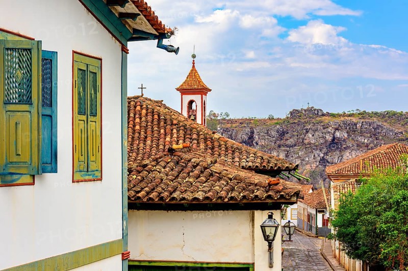 Street in the city of Diamantina with its colonial-style houses and colorful balconies with the church tower in the background, Brasil