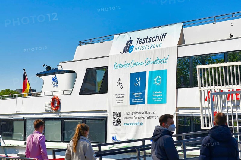 Heidelberg, Germany, April 2021: People waiting at Corona virus test station called 'Testschiff' on boat offering free rapid antigen tests on Neckar river, Europe