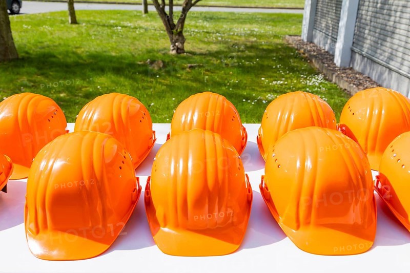 Orange-coloured safety helmets are on display for a factory tour
