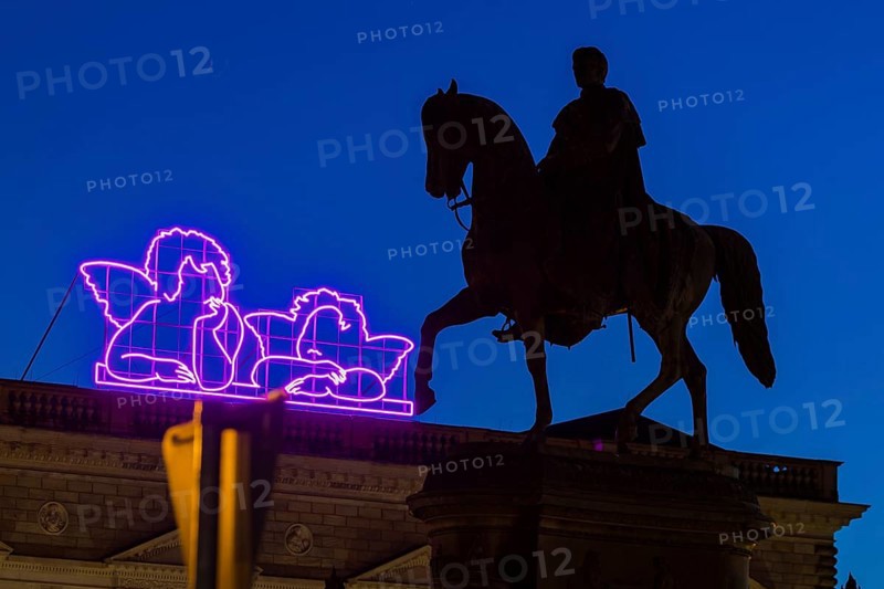 Equestrian statue of King John of Saxony on the evening theatre square. Since the reopening of the Old Masters Picture Gallery, Raphael's angels have been shining in neon colours on the Semper Building