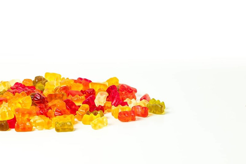 Group of different coloured gummy bears, on white, copying room