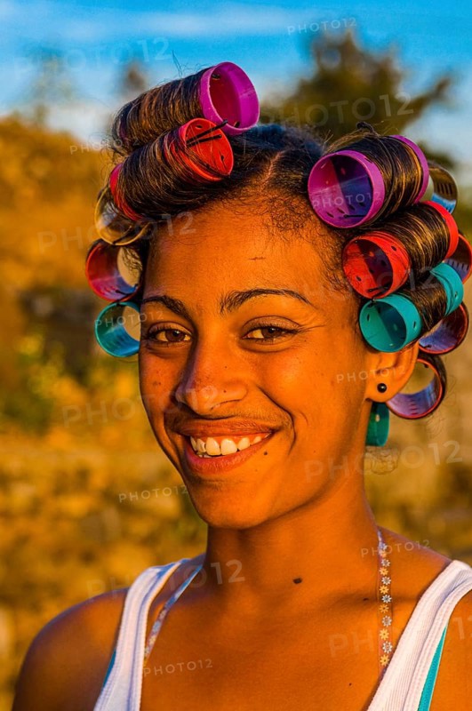 Local woman with curling irons is laughing. Fogo. Cabo Verde. Africa