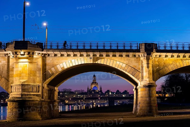 Albertbrücke and Church of Our Lady with the glass dome over the octagon of the Academy of Arts, which is illuminated in blue in protest against the Ukraine war