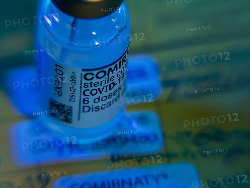 Symbolic image Corona vaccine Comirnaty in front of a vaccination card